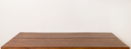 Wooden table top with empty place for your design. Wooden plank table in front of wall.の写真素材