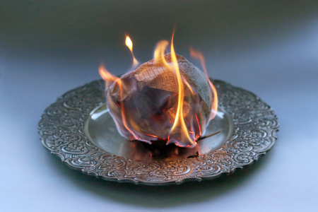Document burning in vintage plate. Paper sheet with text burning in fire.