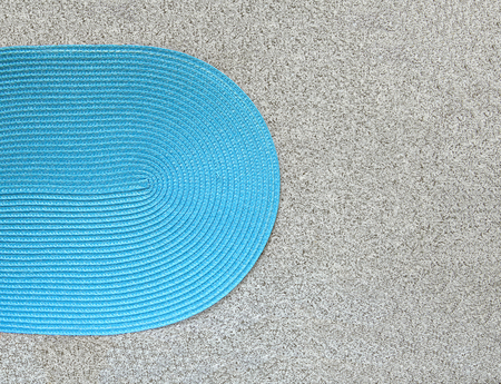 Blue woven napkin on stone background. Oval mat for placing plates on stone tile surface top view.の写真素材