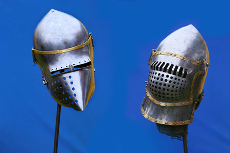 Medieval knight helmets on blue tent background. Iron helmets in the medieval knight tournament.の写真素材