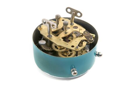 Back side of old mechanical table clock isolated on white background. Clockwork details, pinions and...