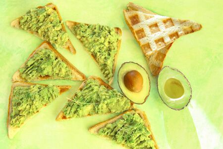 Breakfast  sandwiches with avocado, top view. Toasts with mashed avocado and micro greens.