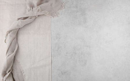 Pure washed linen cloth and tablecloth on light grunge stone background. Natural washed linen fabric on stone tile surface with copy spaceの写真素材