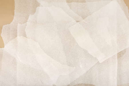 White plastic foam sheet pieces on cardboard background. Closeup of torn foam polyethylene pieces.の写真素材