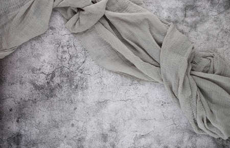 Gauze tablecloth on stone background. Gray gauze fabric on cement top view with copy space.