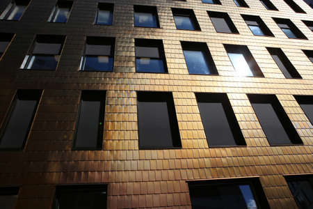 Building facade covered by copper tiles. Fragment of modern business  offices building in Bjorvika...