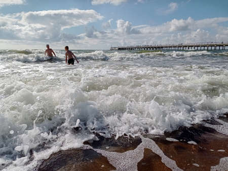 Baltic sea in summer time. Children swimming in the waves.の写真素材
