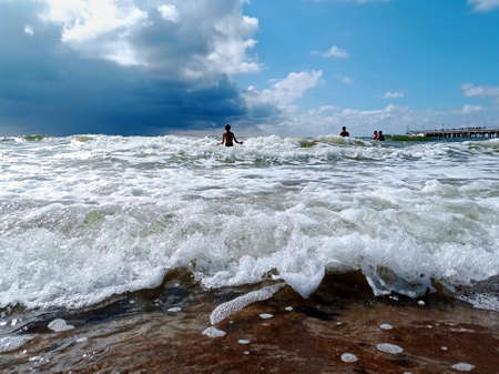 Baltic sea in summer time. Children swimming in the waves.の写真素材