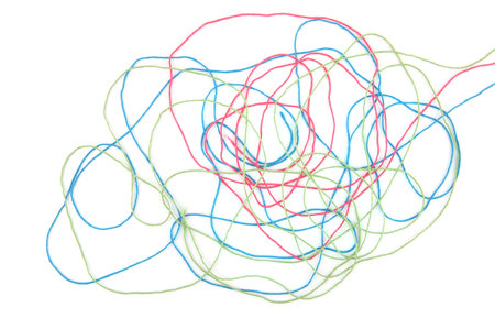 Tangled colorful cotton threads isolated on white background. Abstract thread lines chaos pattern.の写真素材
