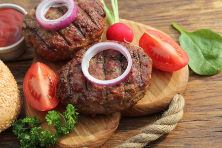 beef burger with onion and sauce on cutting boardの写真素材