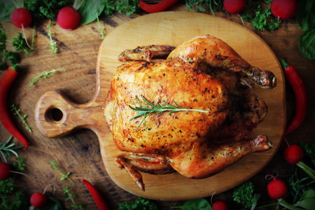 Whole roasted chicken on cutting boardの写真素材