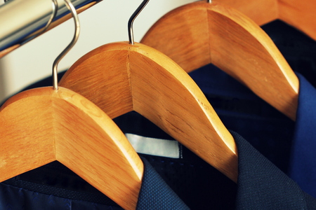 Row of mens suits hanging in closet