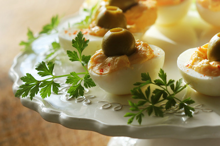 Spicy deviled eggs garnished with green olivesの写真素材