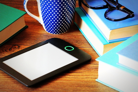 E-book reader and books on wooden background .Education backgroundの写真素材
