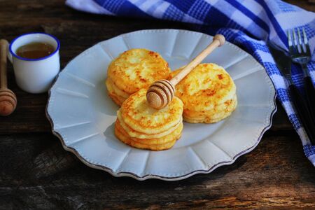 Stack of pancakes with honey syrup on wooden dark background.の写真素材