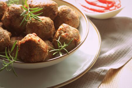 Roasted meatballs with tomato sauce , delicious meat cutlets on wooden table .の写真素材