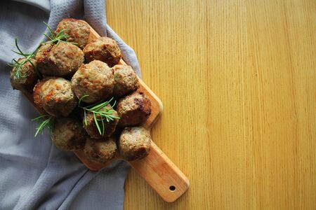 Roasted meatballs , delicious meat cutlets on wooden cutting board. Top view