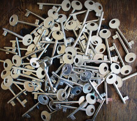 Many keys on brown wooden background