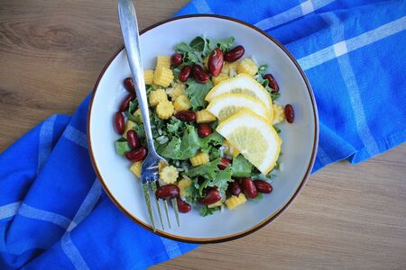 Healthy raw kale and corn , red beans salad with lemon and dressing . Winter salad. Top view .の写真素材