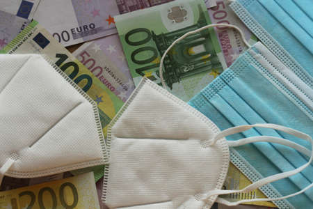Medical face masks and money. Surgical face mask. COVID-19 Has Caused A Shortage Of Face Masks. Euro...