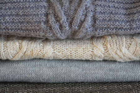 Stack of cozy knitted gray sweaters . Retro style. Warm concept .
