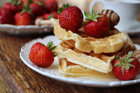 Belgian waffles with fresh berries strawberry , honey and cappuccino coffee for breakfast .の写真素材
