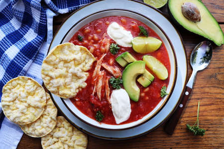 Chicken tortilla chili soup with beans, avocado, lime, . Mexican traditional dish . Top viewの写真素材
