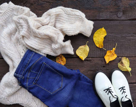 Autumn female outfit. Set of clothes, shoes and accessories on wooden backgroundの写真素材