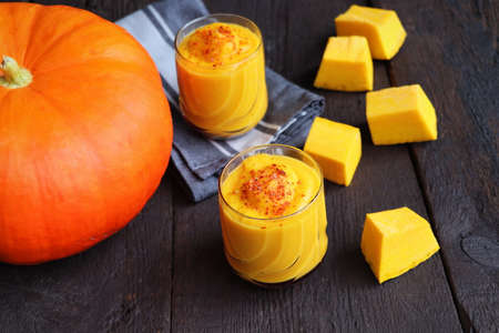 Pumpkin smoothie with spices on a wooden background Top view. Copy space .の写真素材