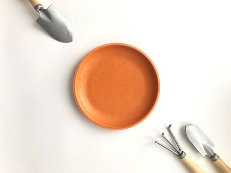 Gardening tools with saucer arranged on white background.の写真素材