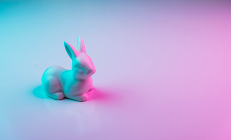 White Easter bunny with colorful ultraviolet holographic neon lights. Creative concept.の写真素材