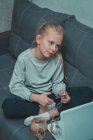 the girl is bored engaged in hobbies studying on a laptop watching a video lesson at home