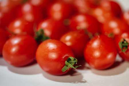 Bunch of red tasty fresh tomatos on the white background.の写真素材