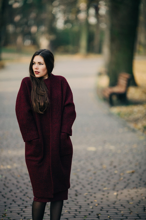 young woman in coat posingの写真素材