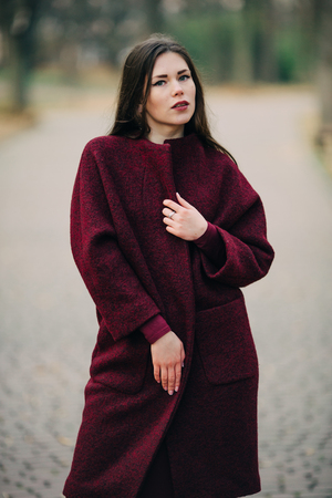 young woman in  coat posingの写真素材