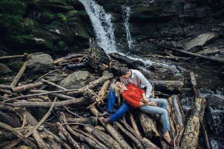 loving couple near a waterfall in forest.の写真素材