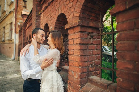 beautiful wedding couple hugging standing near old buildingの写真素材