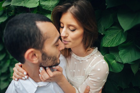 portrait of beautiful bride hugging her handsome groom outdoorsの写真素材