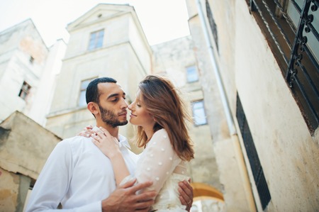 portrait of beautiful bride hugging her handsome groom outdoorsの写真素材