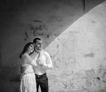 portrait of beautiful bride hugging her handsome groom outdoorsの写真素材