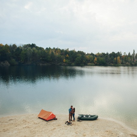 Young couple in love, boat ride on the river, next to the forestの写真素材
