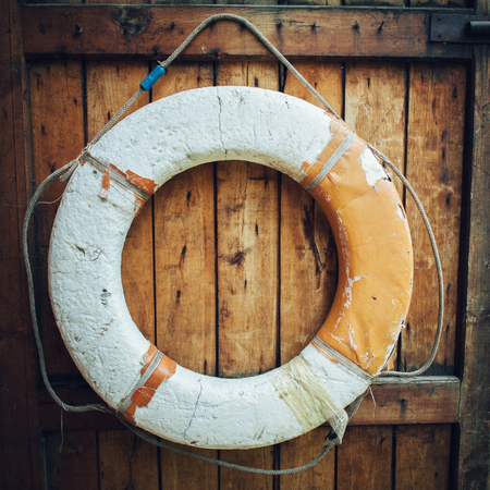 Vintage Lifebuoy Hanging On A Rustic Wooden Wall With Copy Spaceの写真素材