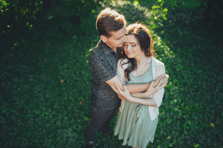 young man gently hugs the girl in the parkの写真素材