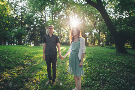 Shot of a young couple holding hands and running through the parの写真素材