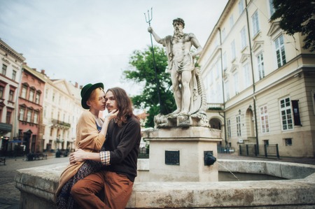 Young couple sitting next to the monument in sunny morningの写真素材