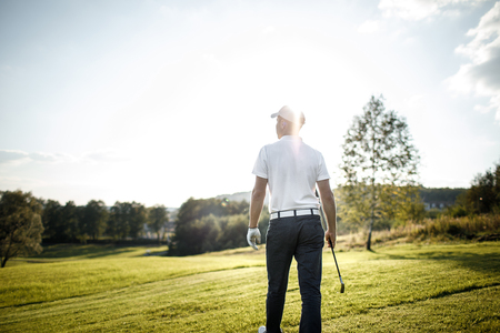 Man playing golf on a golf course in the sunの写真素材