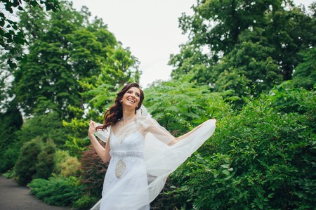The beautiful bride in a white poses in the parkの写真素材
