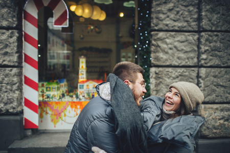 Happy couples on the city square decorated for a Christmas markeの写真素材