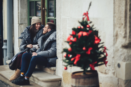 Classy groom and his gorgeous bride pose outside in winter coatsの写真素材