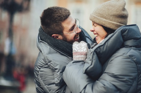 Classy groom and his gorgeous bride pose outside in winter coatsの写真素材